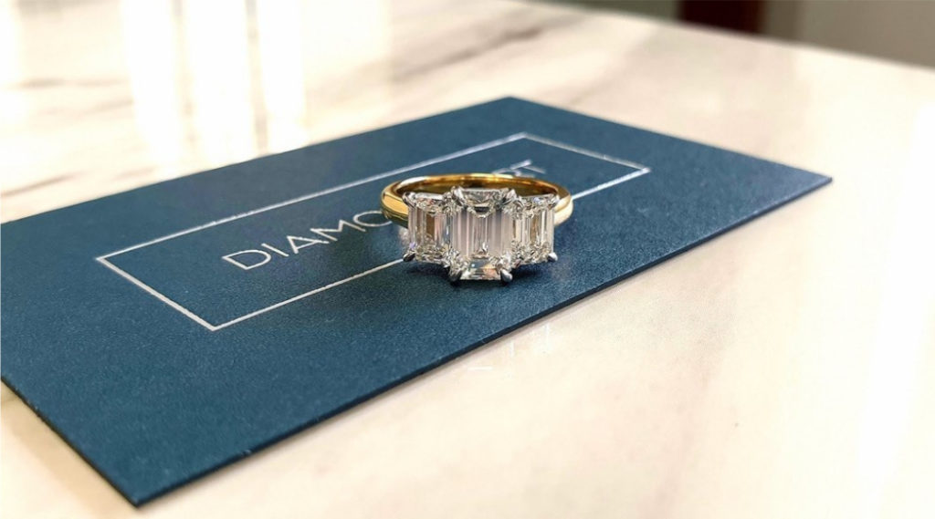 Emerald diamond trilogy engagement ring with emerald diamonds yellow gold