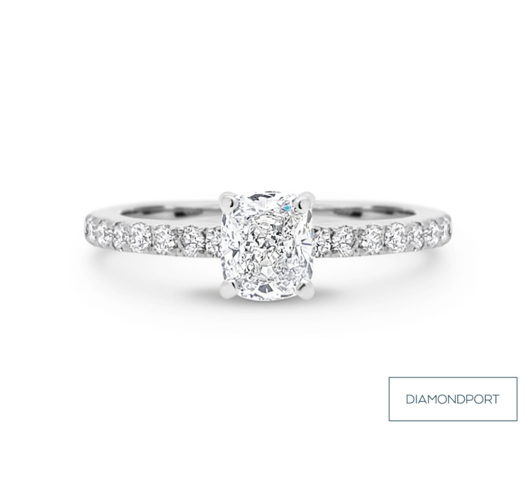 Engagement ring with cushion cut diamond and diamonds in the band