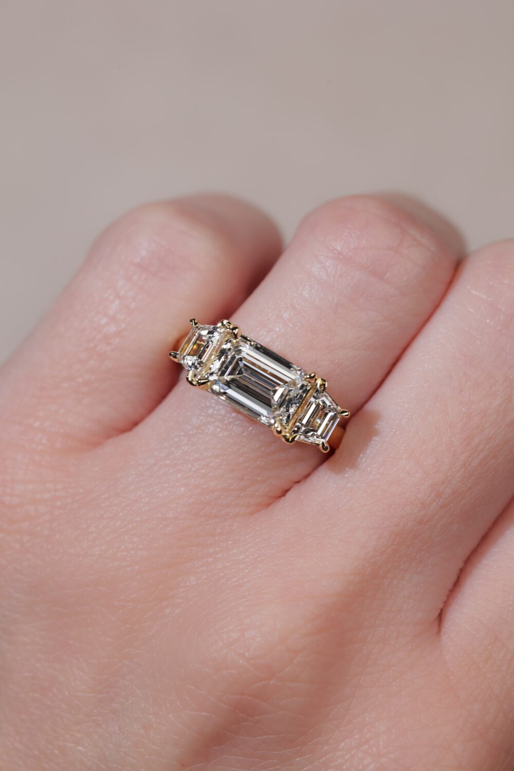 East west emerald cut with trapezoid three stone ring yellow gold 1 scaled