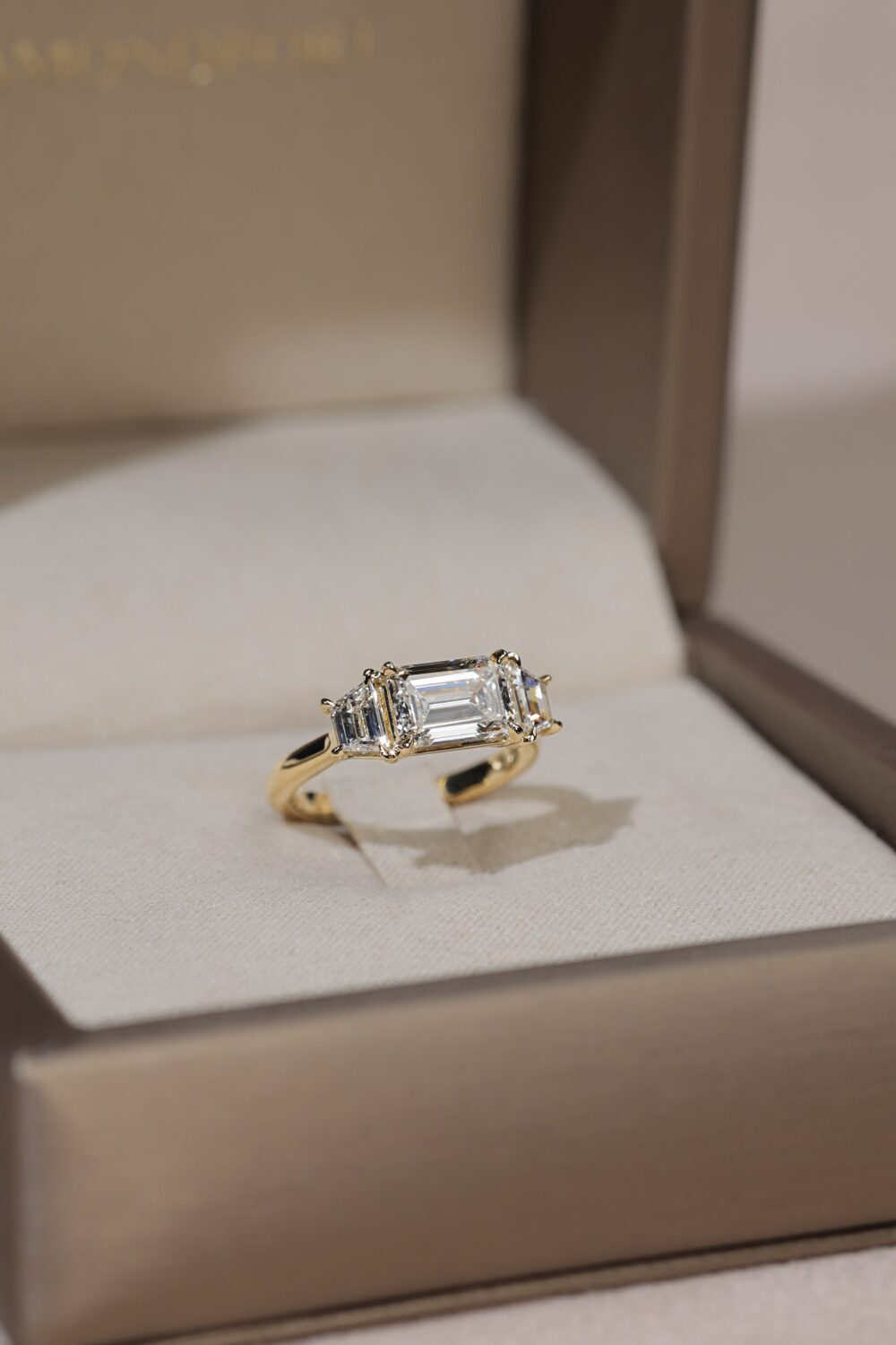 East west emerald cut with trapezoid three stone ring yellow gold 2 scaled