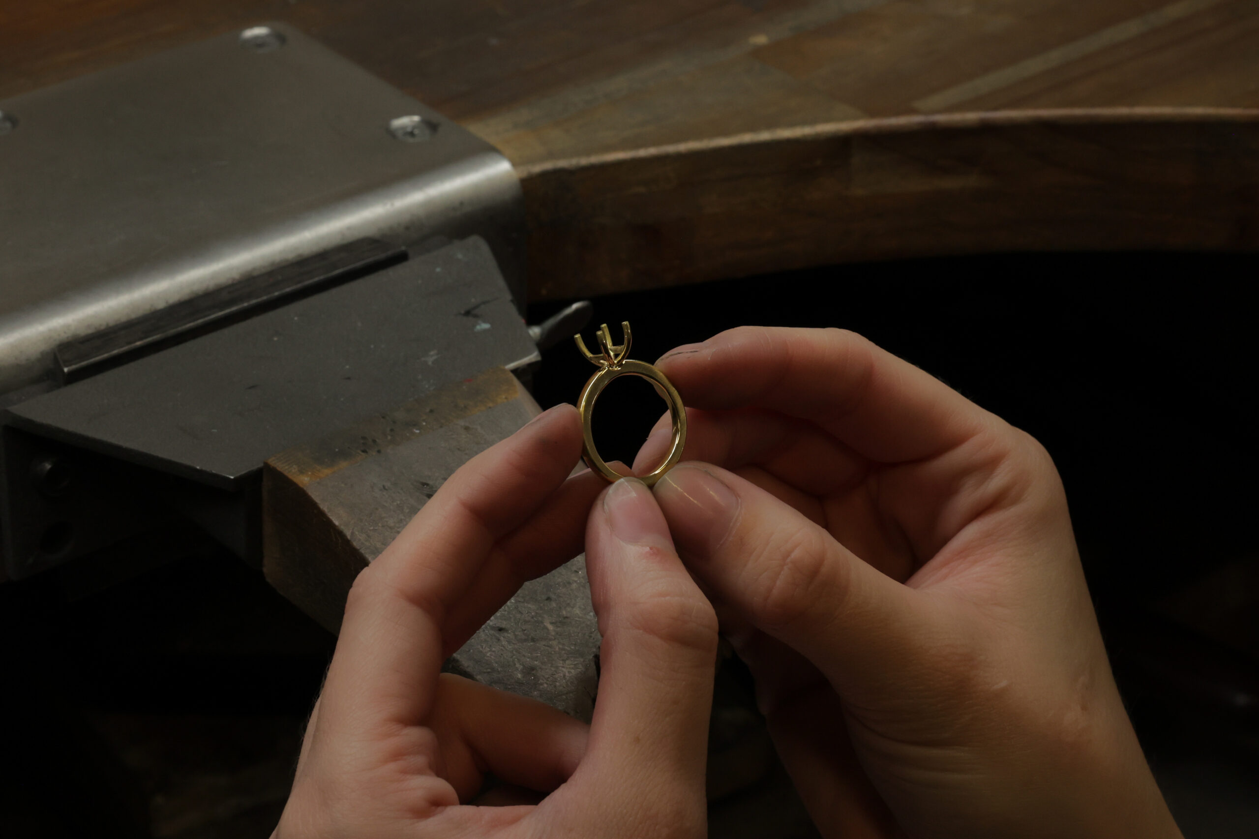 bench jeweller working on yellow gold solitaire ring