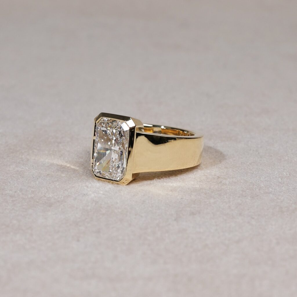 Wide bezel set radiant cut lab diamond ring in yellow gold