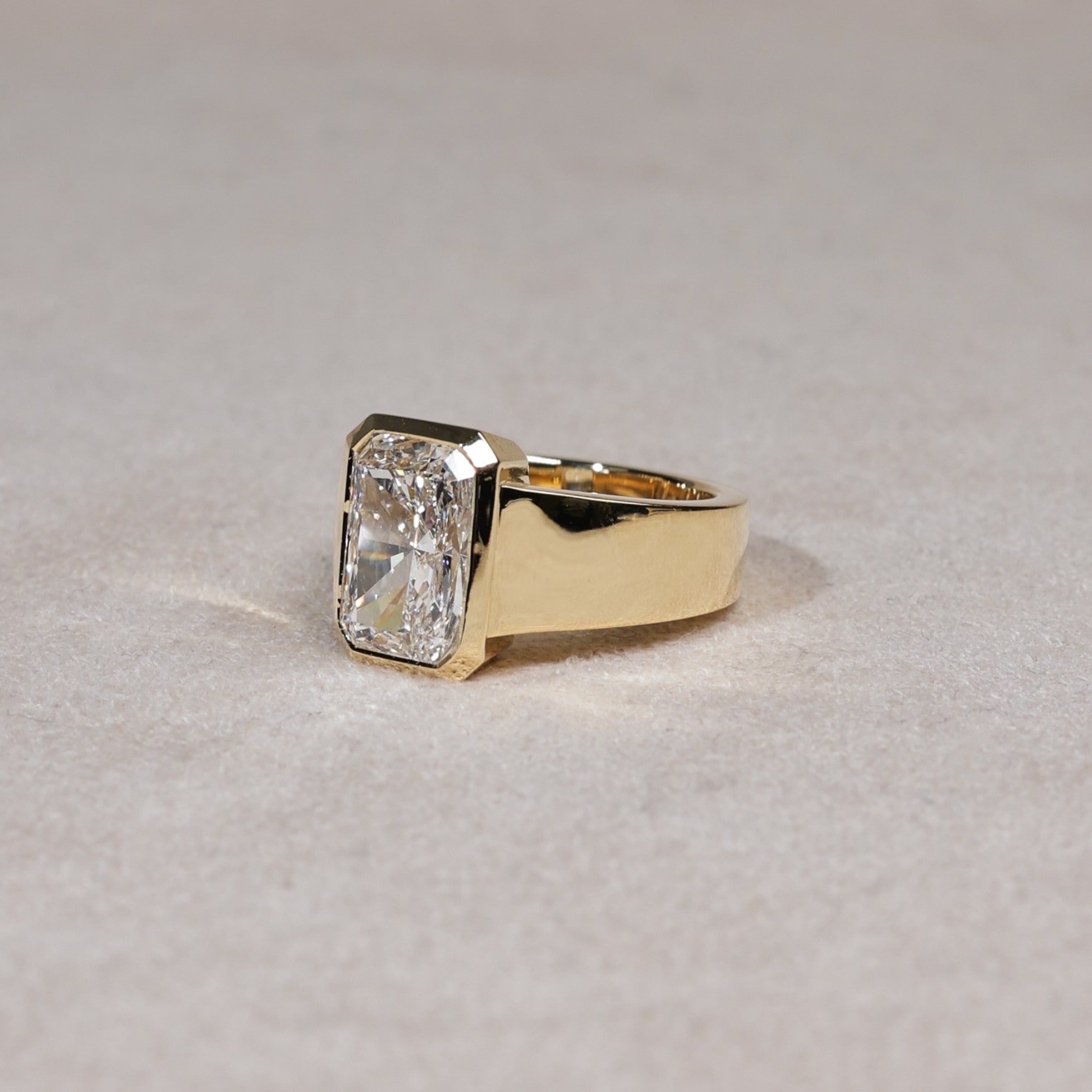 Wide bezel set radiant cut lab diamond ring in yellow gold