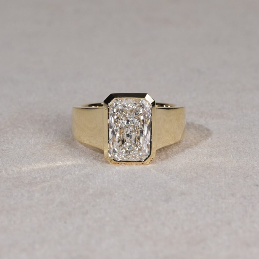 Wide bezel set radiant cut lab diamond ring in yellow gold