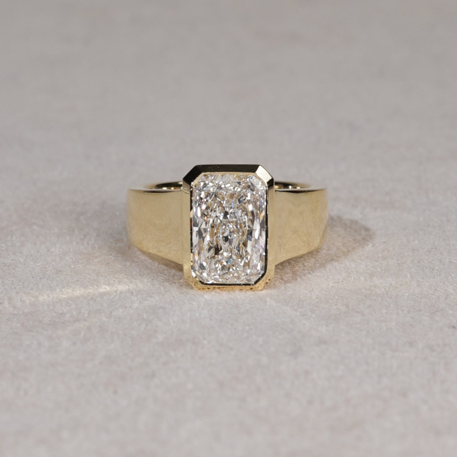Wide bezel set radiant cut lab diamond ring in yellow gold