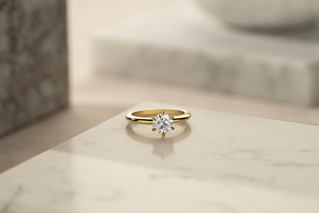 brilliant round engagement ring on marble table